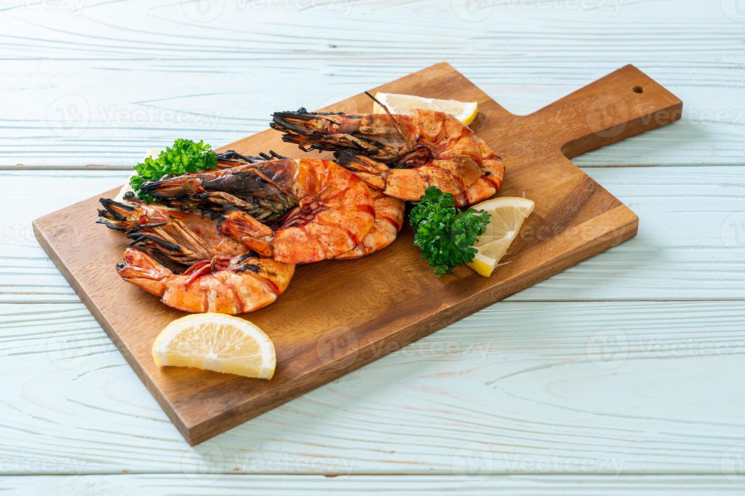 Grilled tiger prawns or shrimps with lemon on a plate photo