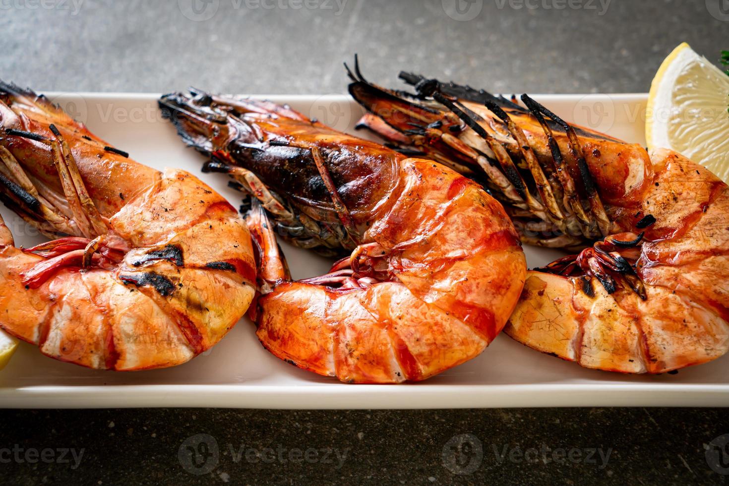 Langostinos a la plancha o camarones con limón en un plato foto