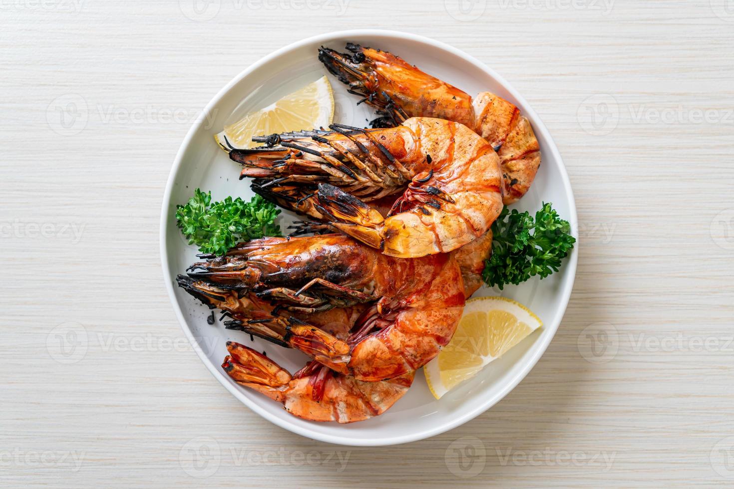 Grilled tiger prawns or shrimps with lemon on a plate photo