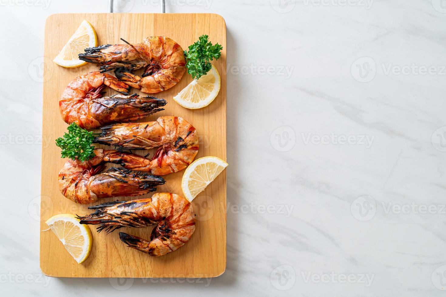 Grilled tiger prawns or shrimps with lemon on a plate photo