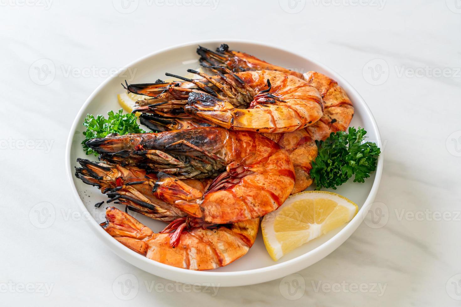 Grilled tiger prawns or shrimps with lemon on a plate photo