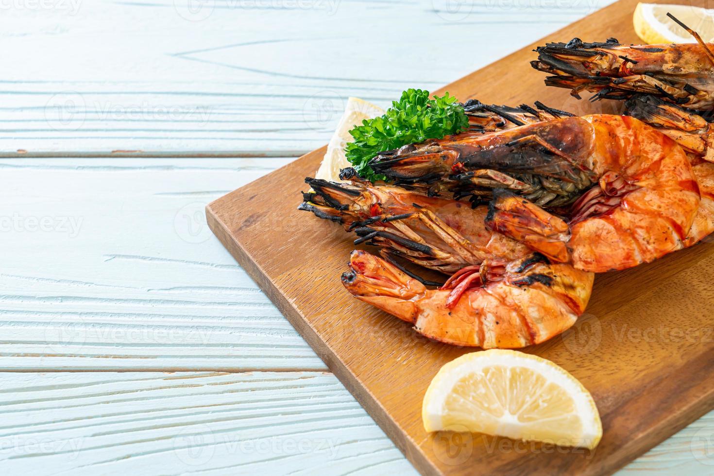 Grilled tiger prawns or shrimps with lemon on a plate photo