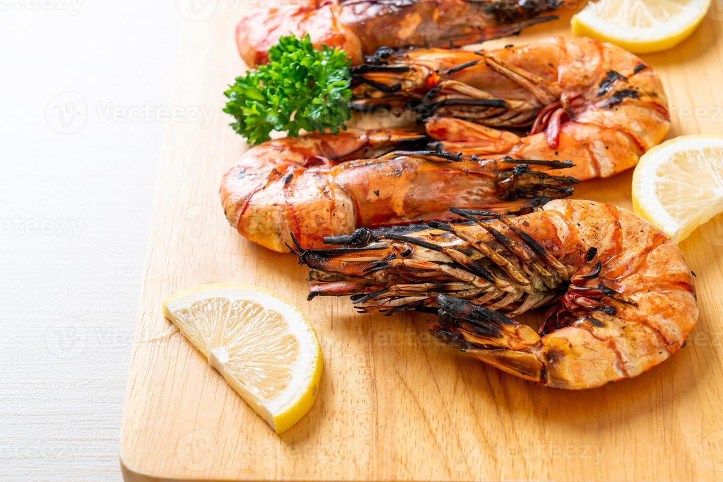 Grilled tiger prawns or shrimps with lemon on a plate photo