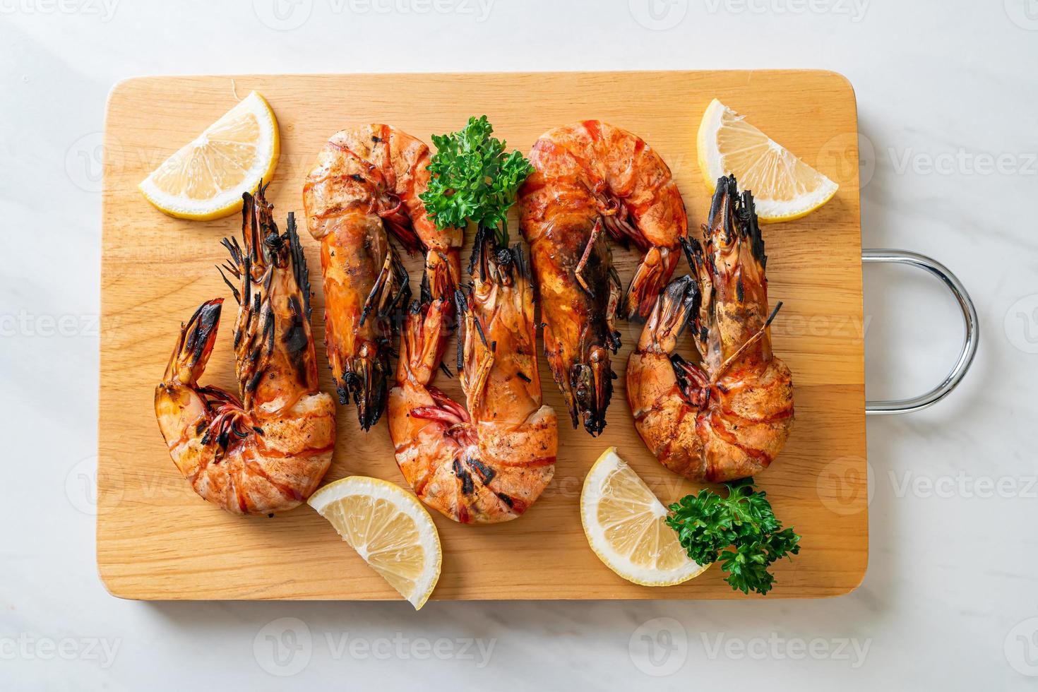 Grilled tiger prawns or shrimps with lemon on a plate photo