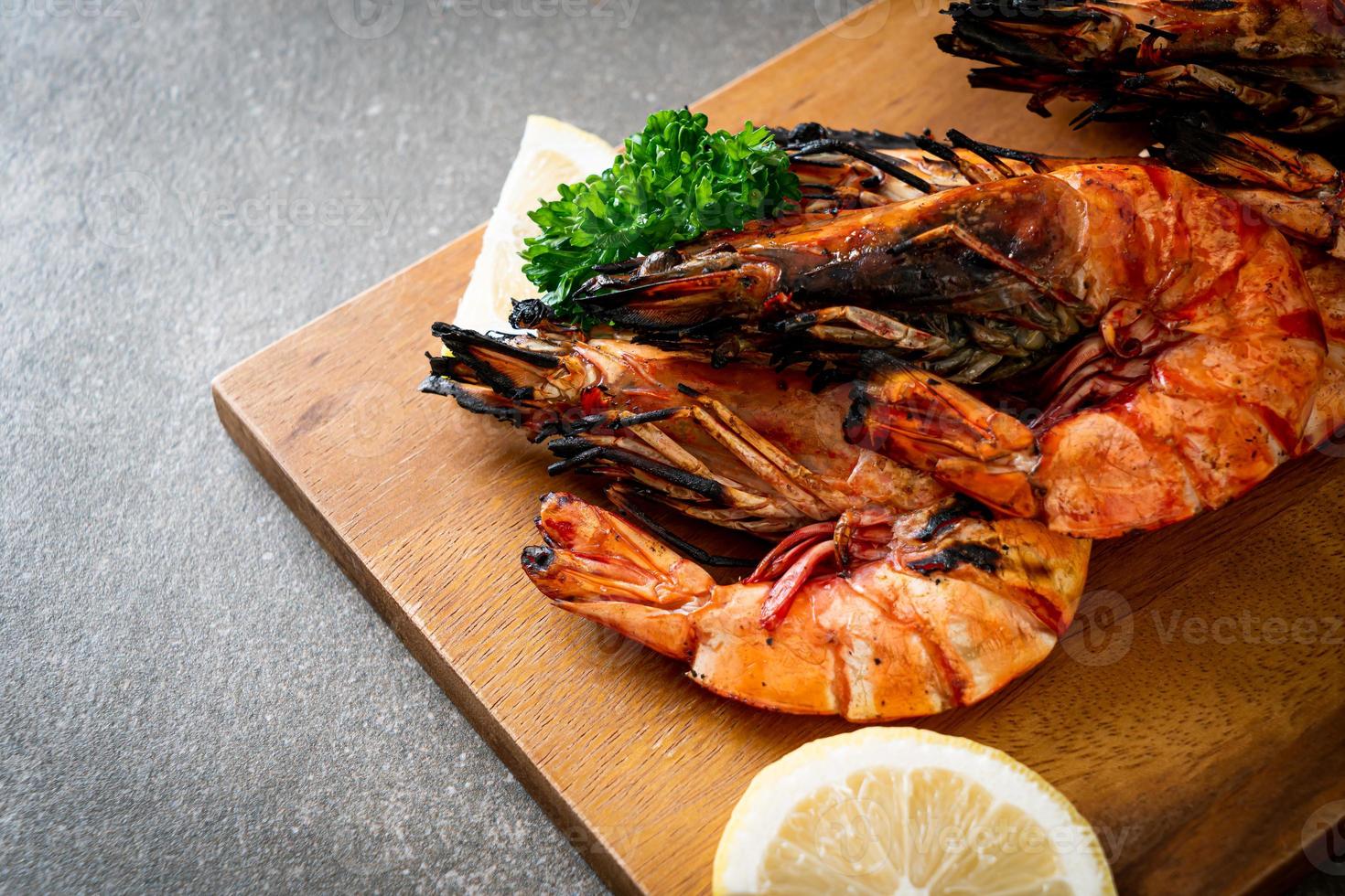 Grilled tiger prawns or shrimps with lemon on a plate photo