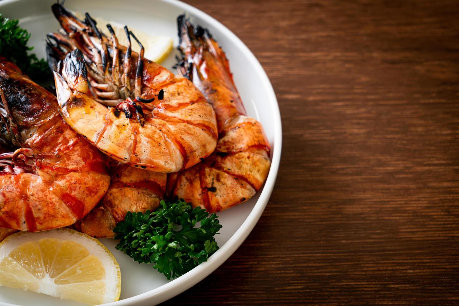 Grilled tiger prawns or shrimps with lemon on a plate photo