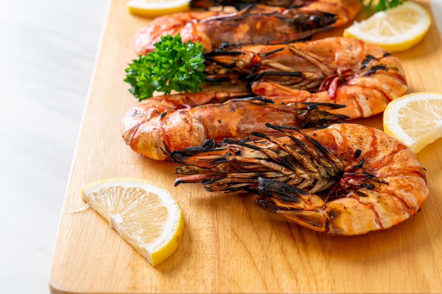 Grilled tiger prawns or shrimps with lemon on a plate photo