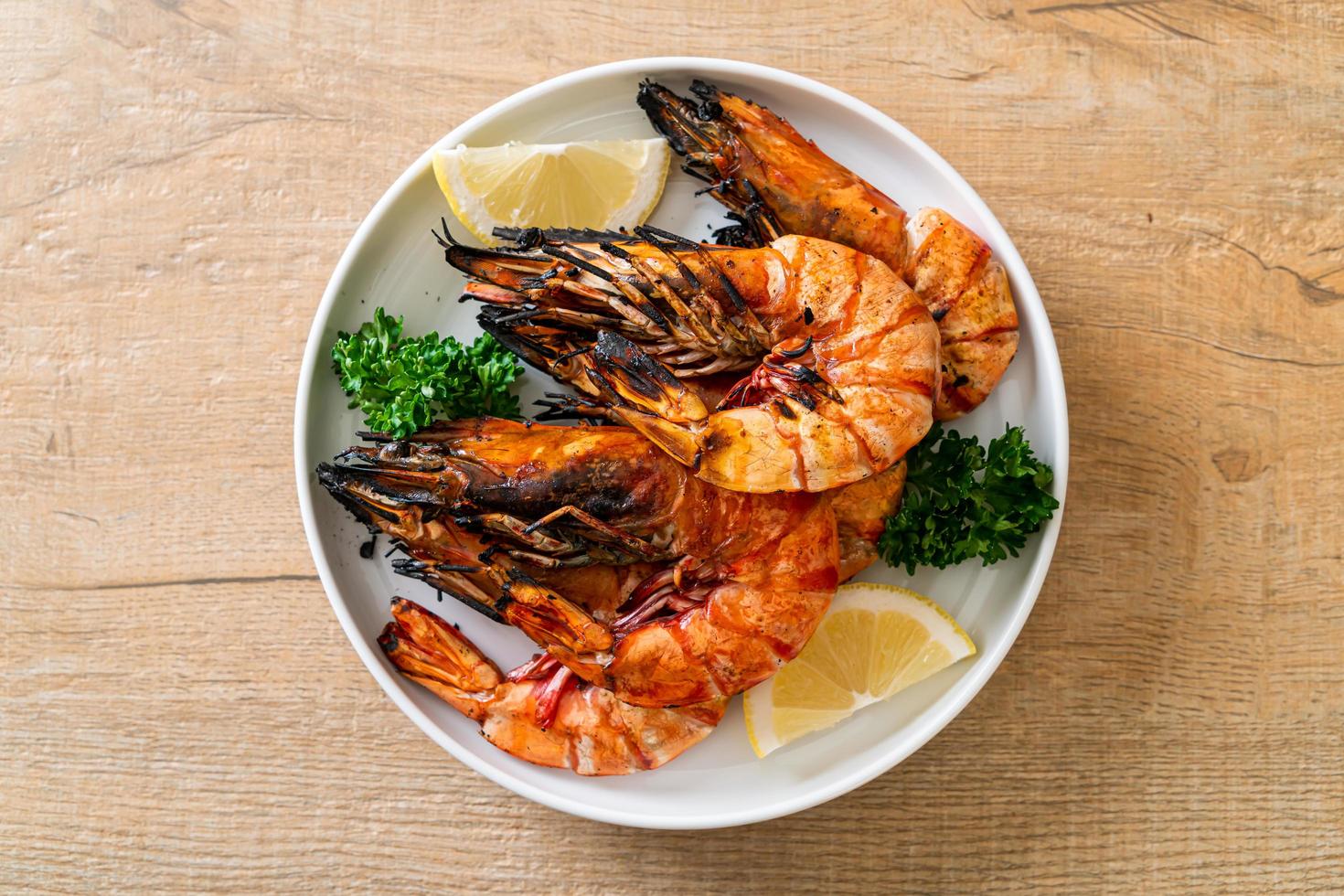 Langostinos a la plancha o camarones con limón en un plato foto