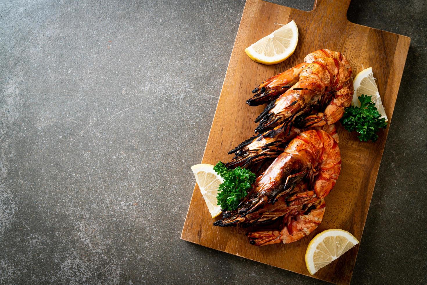 Langostinos a la plancha o camarones con limón en un plato foto