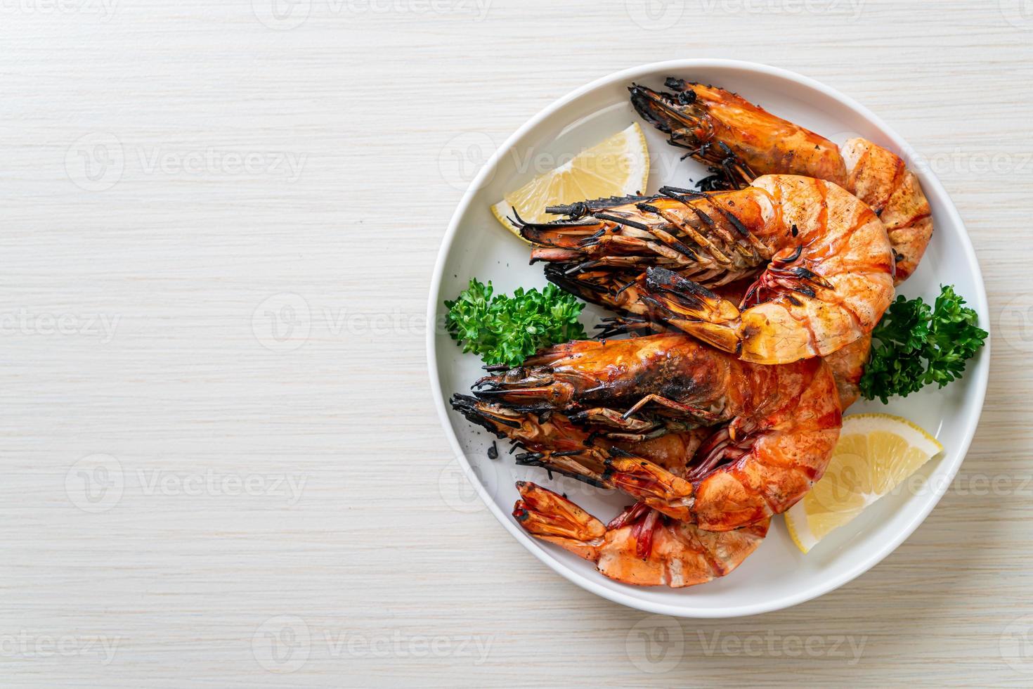 Grilled tiger prawns or shrimps with lemon on a plate photo