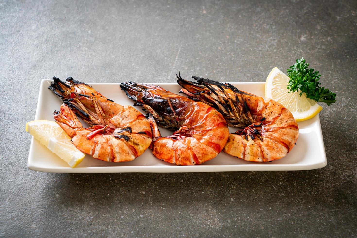 Langostinos a la plancha o camarones con limón en un plato foto