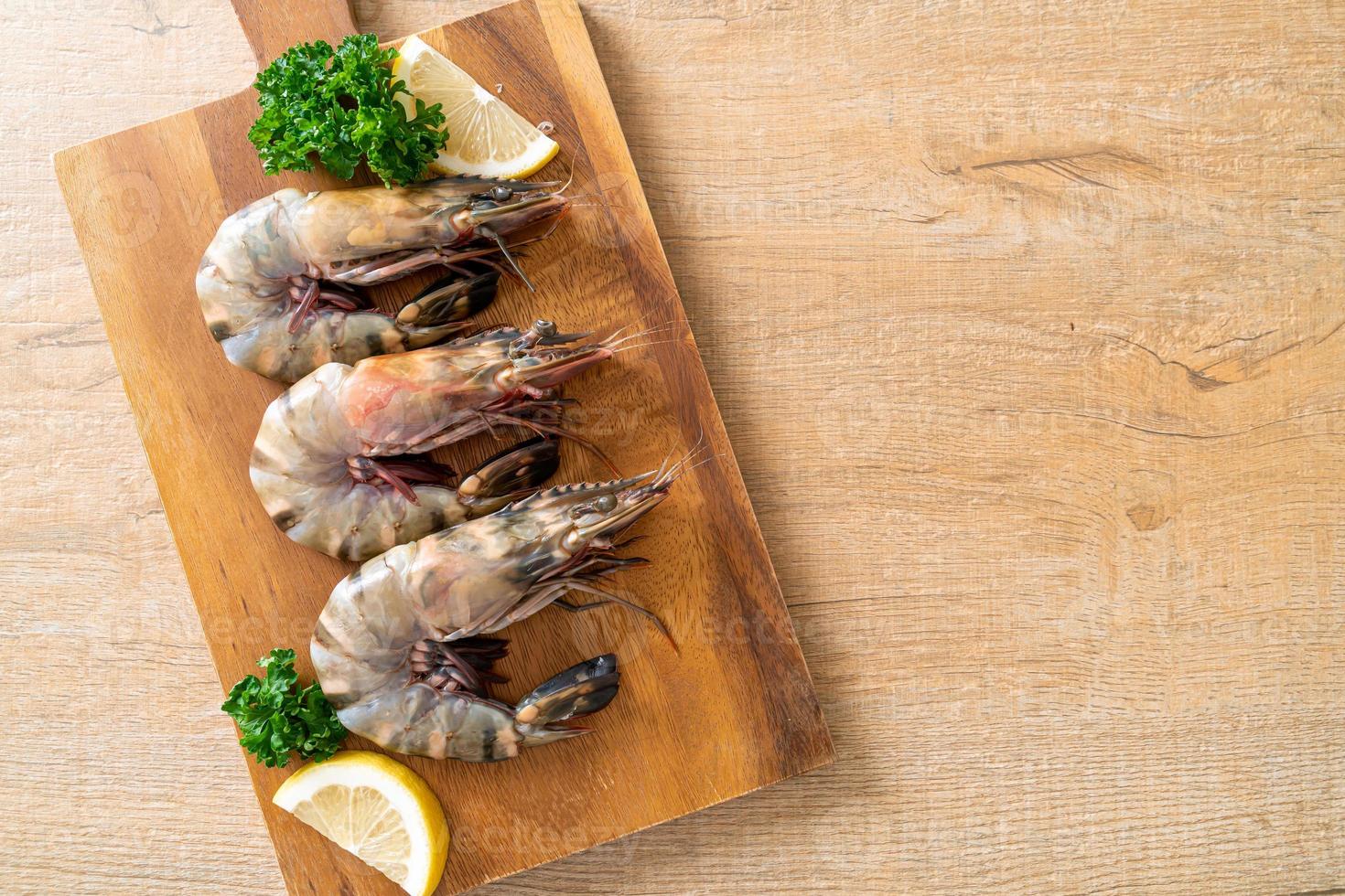 Fresh tiger prawn or shrimp on wood board photo