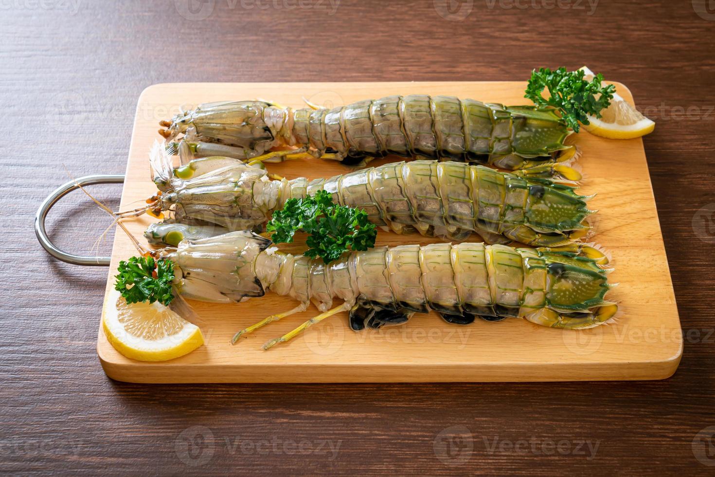 Fresh mantis shrimp with lemon on a board photo