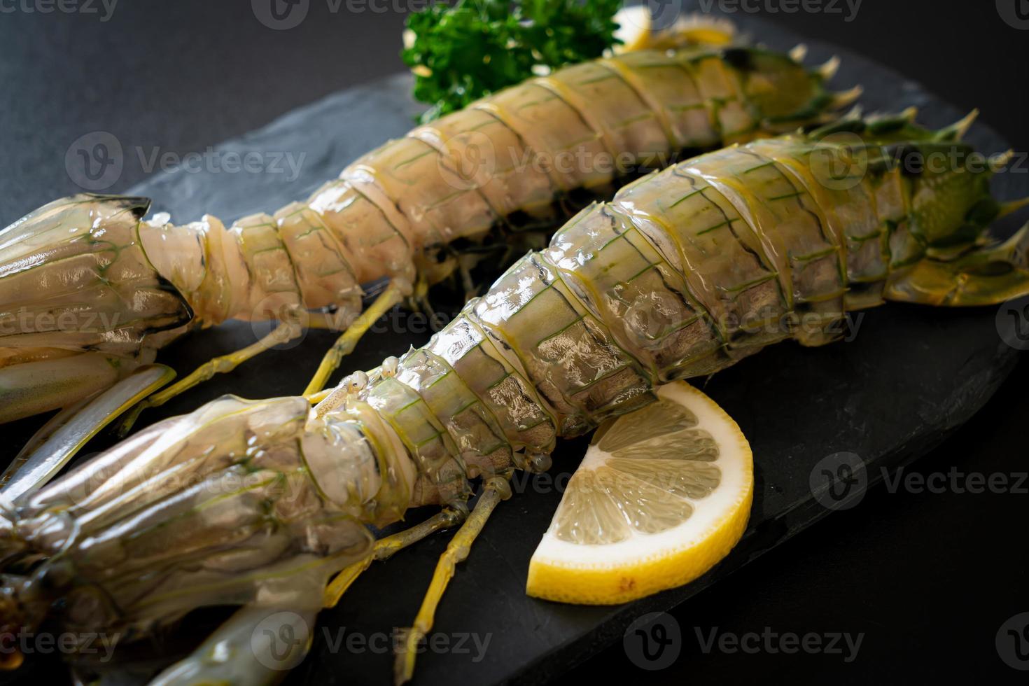 Fresh mantis shrimp with lemon on a board photo