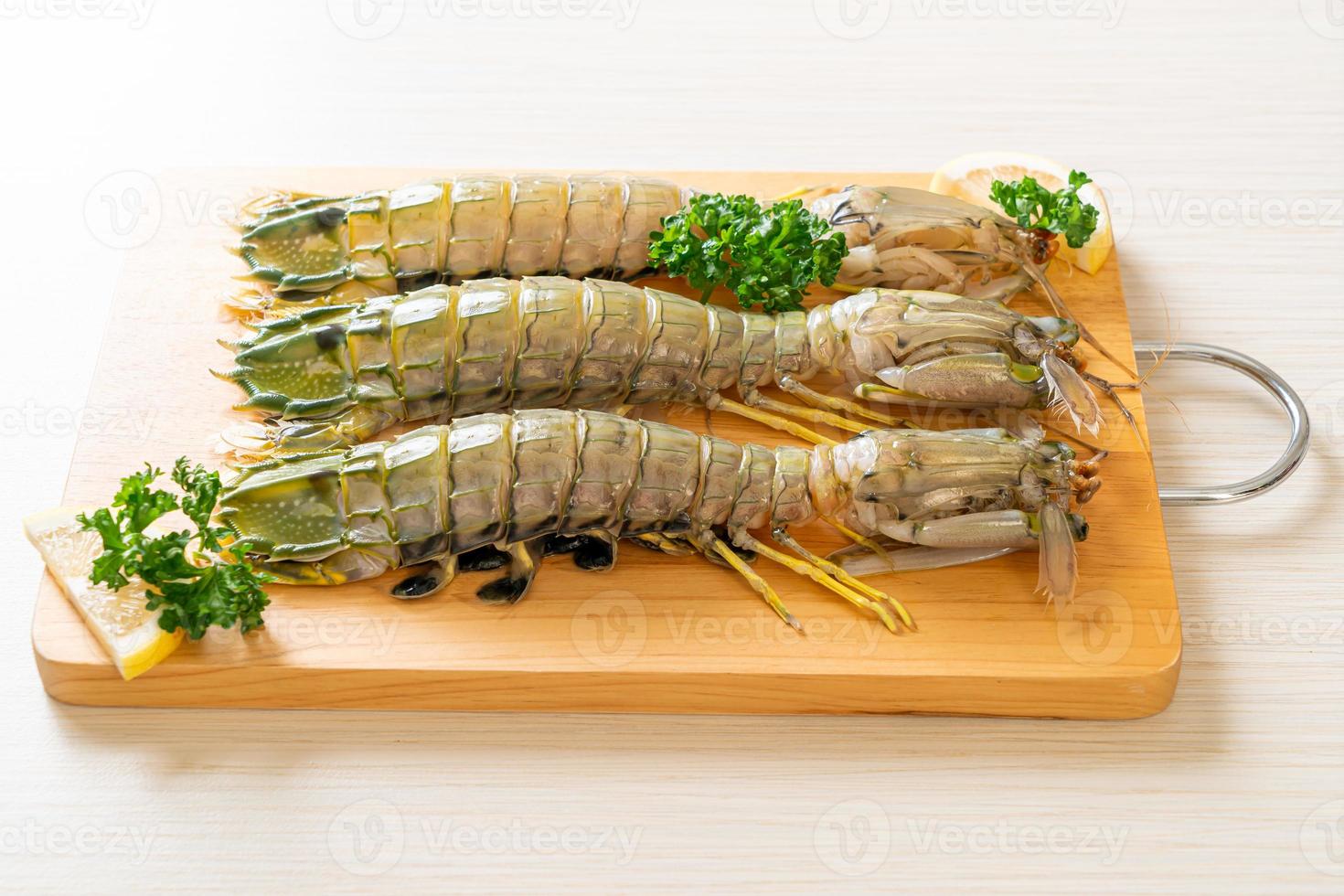 Fresh mantis shrimp with lemon on a board photo