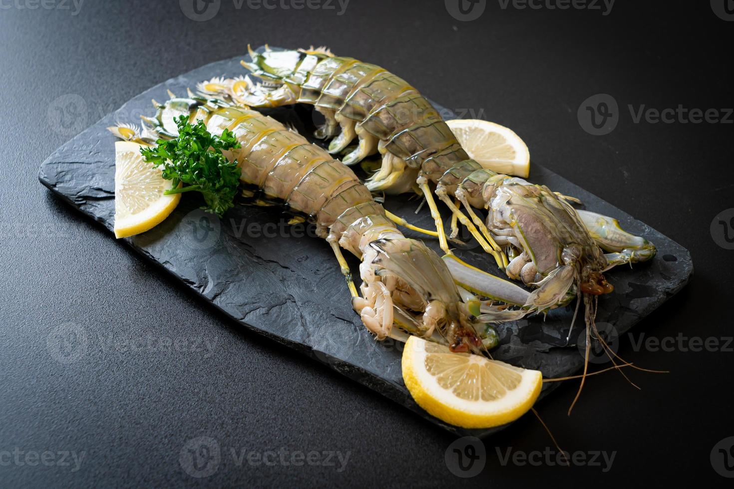 Fresh mantis shrimp with lemon on a board photo