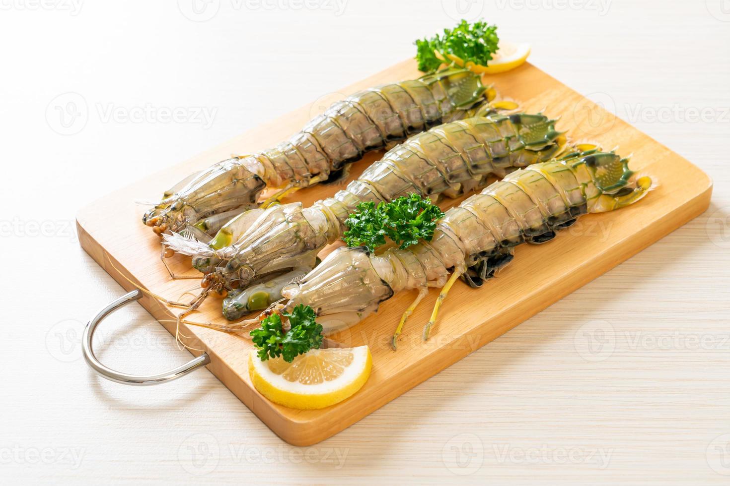 Fresh mantis shrimp with lemon on a board photo