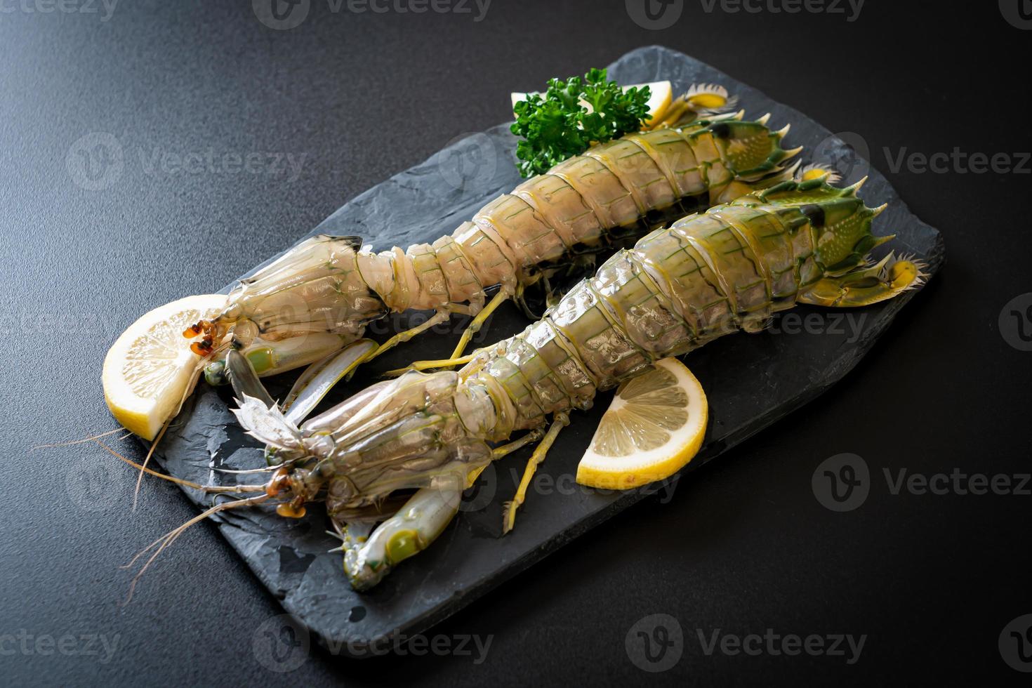 Fresh mantis shrimp with lemon on a board photo