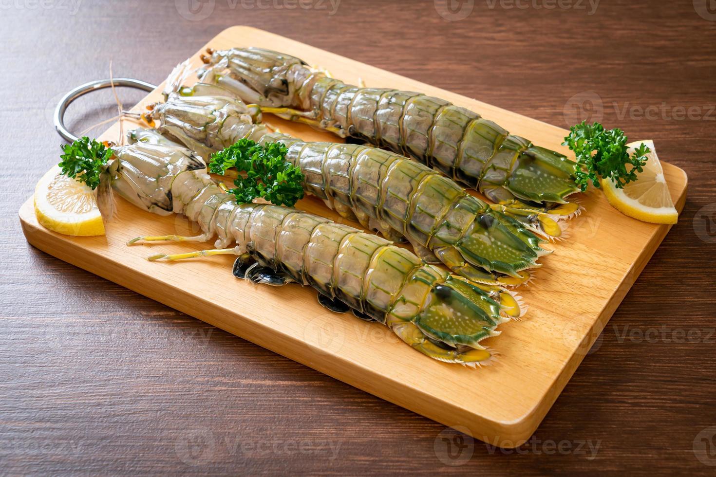 Fresh mantis shrimp with lemon on a board photo