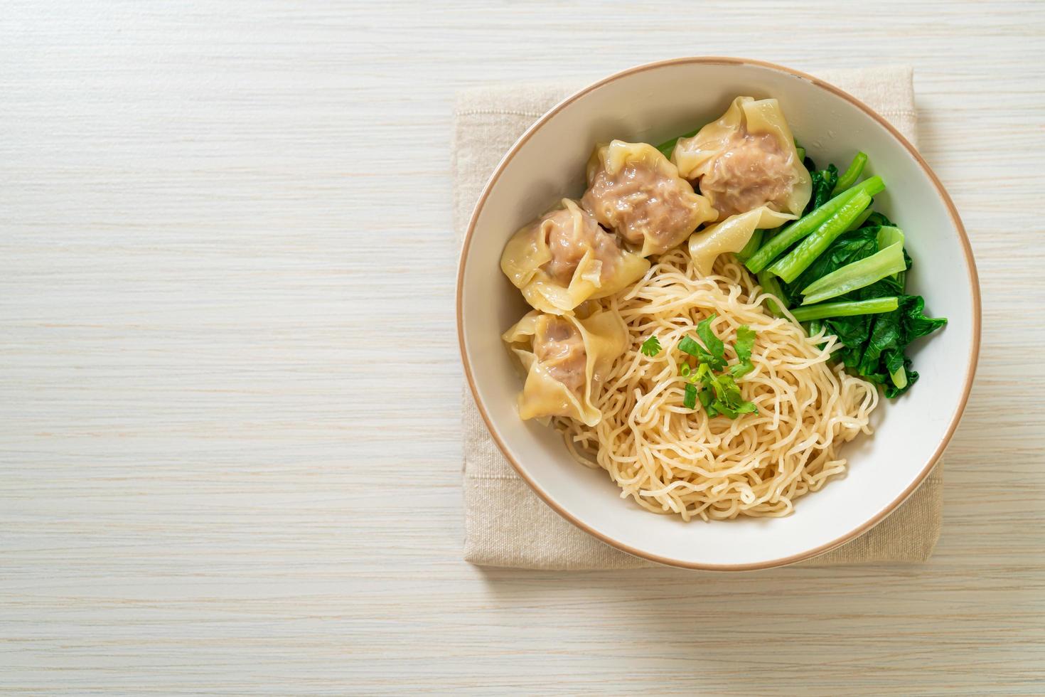 Dried egg noodles with pork wonton or pork dumplings without soup Asian food style photo