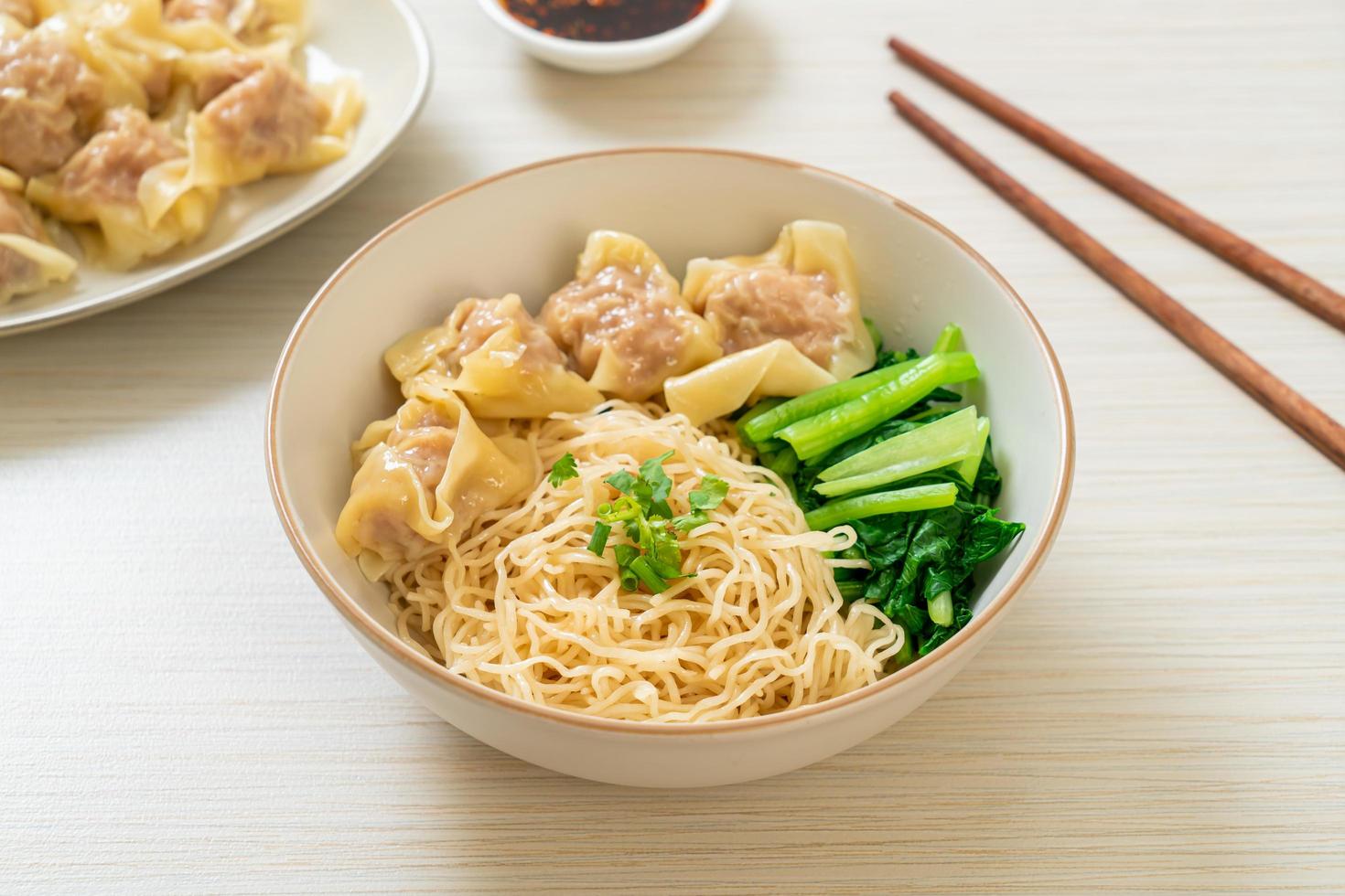 Dried egg noodles with pork wonton or pork dumplings without soup Asian food style photo
