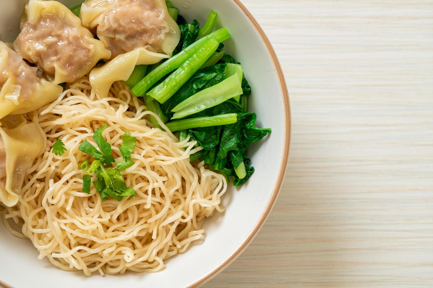 Dried egg noodles with pork wonton or pork dumplings without soup Asian food style photo