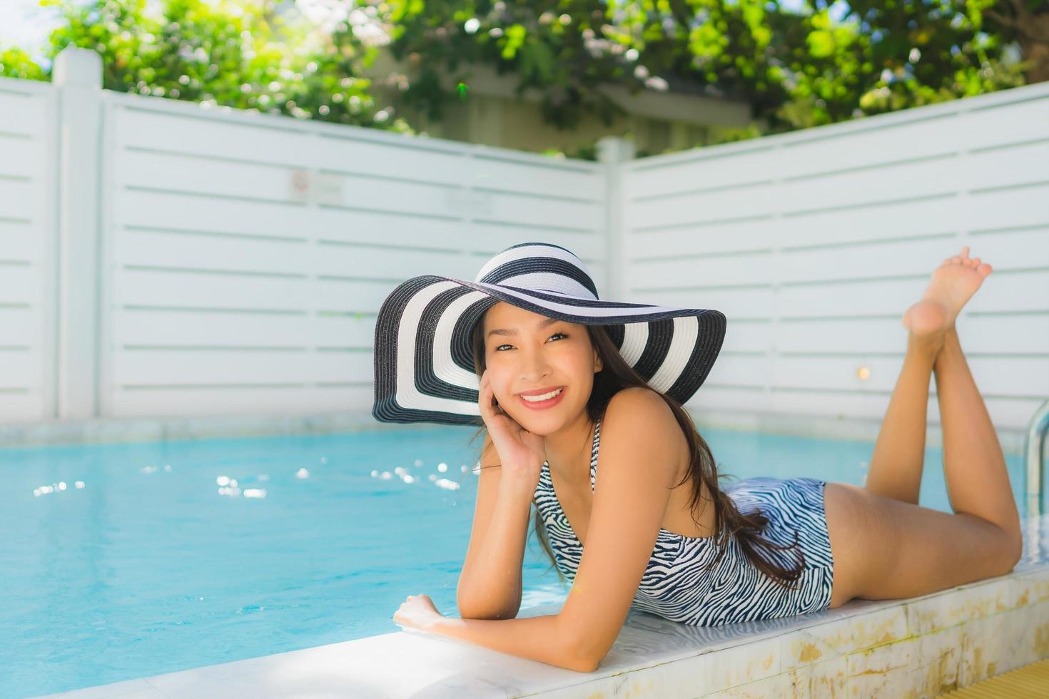 retrato, hermoso, joven, mujer asiática, feliz, sonrisa, relajarse, alrededor, piscina exterior foto