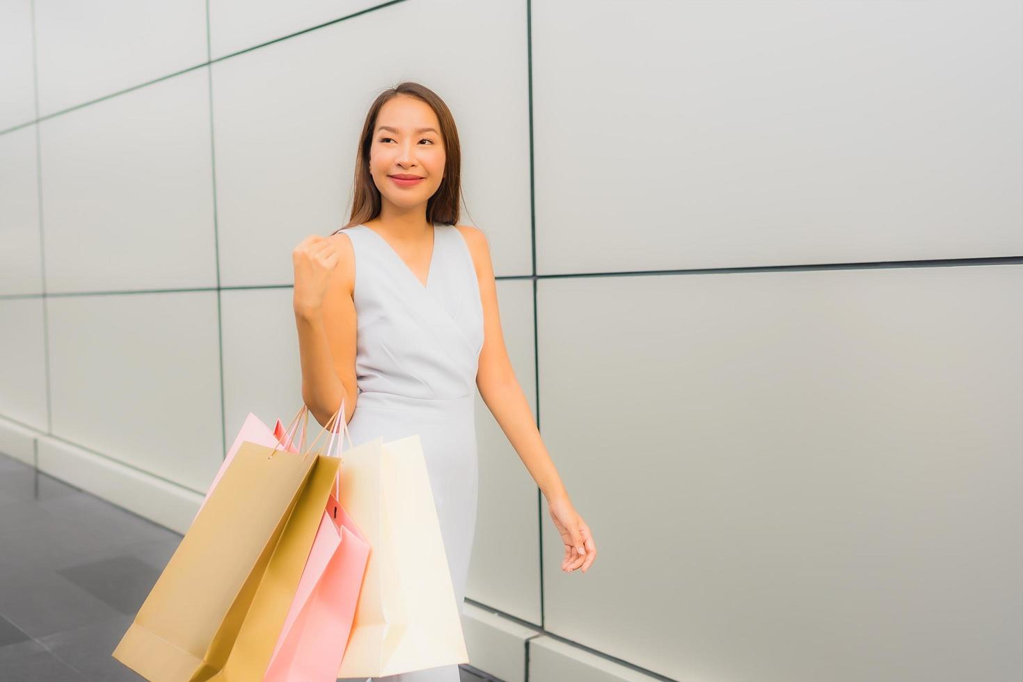 Retrato hermosa joven asiática feliz y sonrisa con bolsa de compras de los grandes almacenes foto