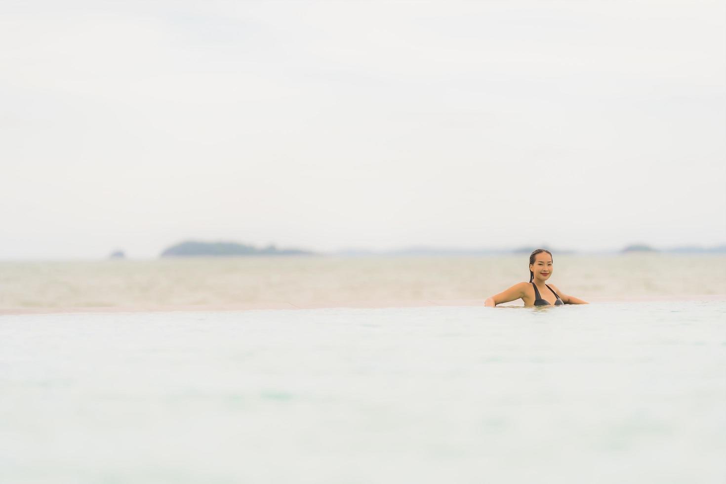 Portrait beautiful young asian woman wear bikini around swimming pool in hotel resort nearly sea ocean beach photo