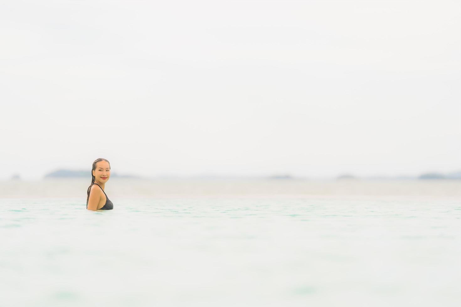 Portrait beautiful young asian woman wear bikini around swimming pool in hotel resort nearly sea ocean beach photo