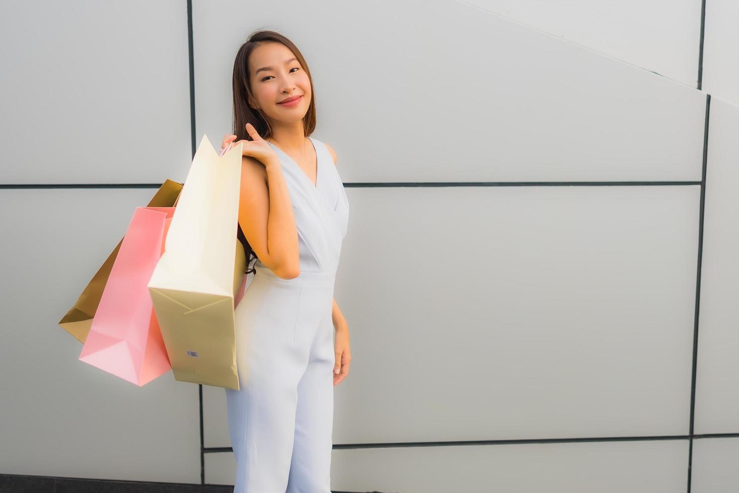 Retrato hermosa joven asiática feliz y sonrisa con bolsa de compras de los grandes almacenes foto