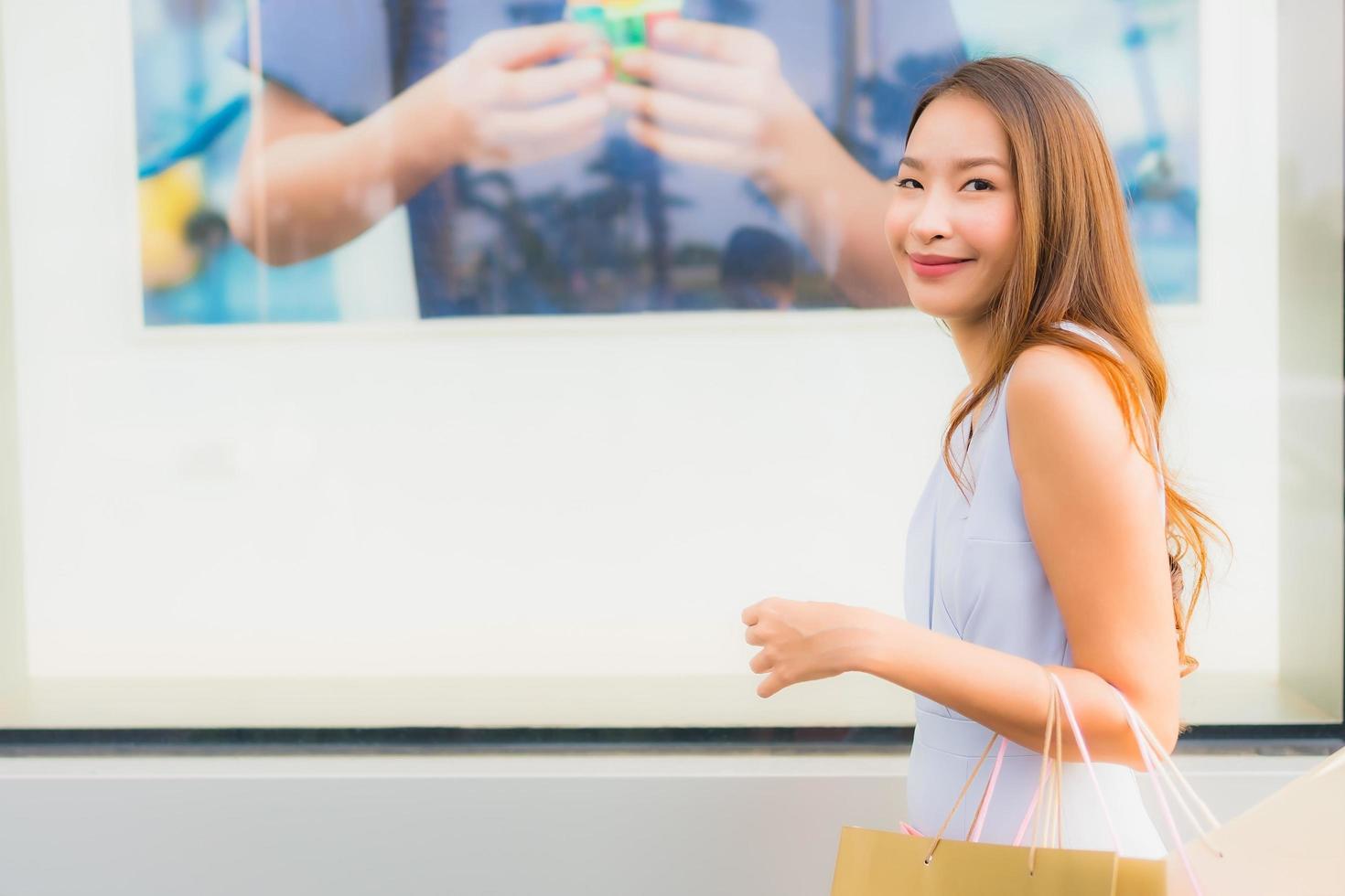 Retrato hermosa joven asiática feliz y sonrisa con bolsa de compras de los grandes almacenes foto