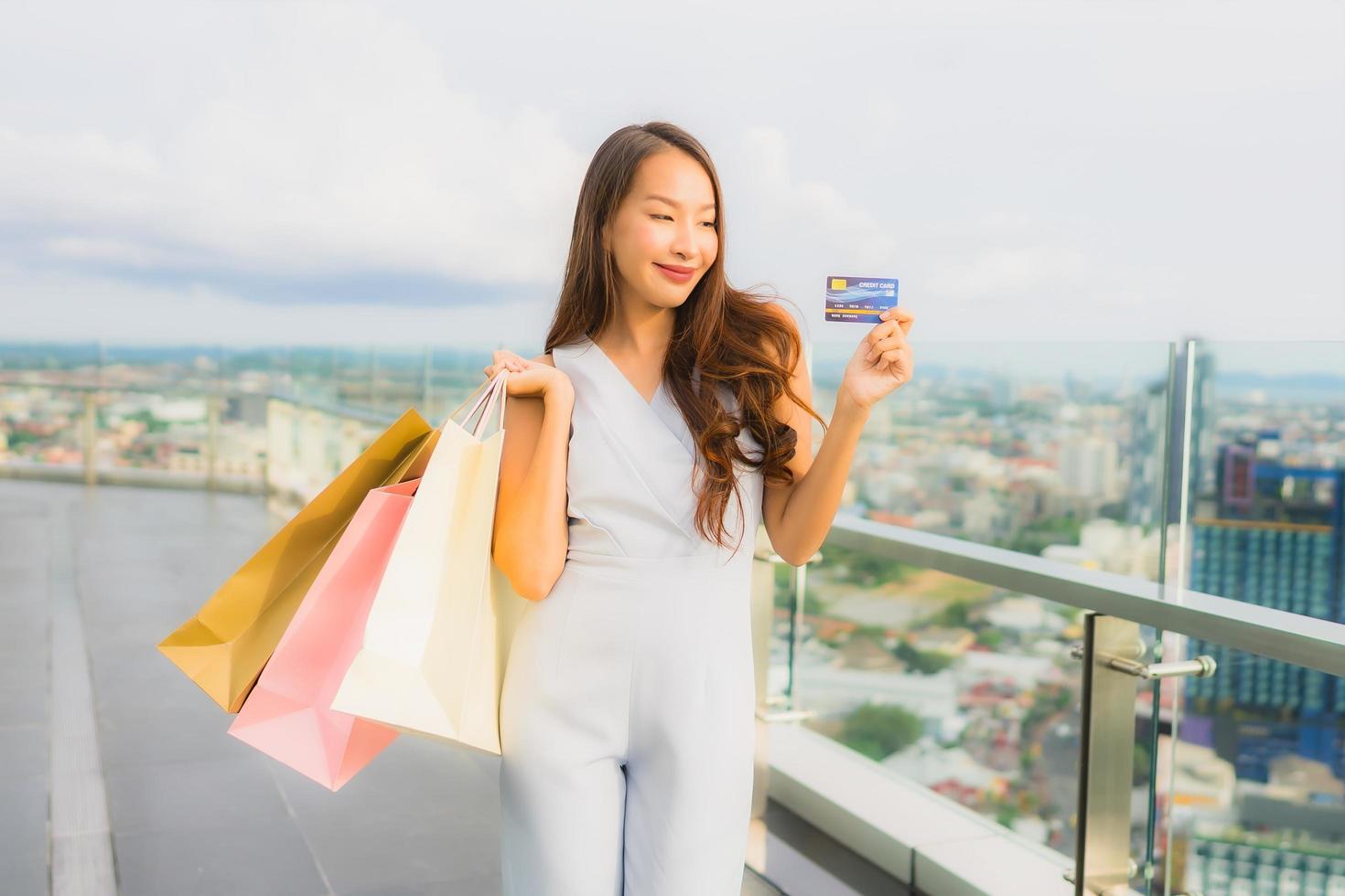 retrato, hermoso, joven, mujer asiática, feliz, y, sonrisa, con, tarjeta de crédito, para, bolsa de compras, de, grandes almacenes foto