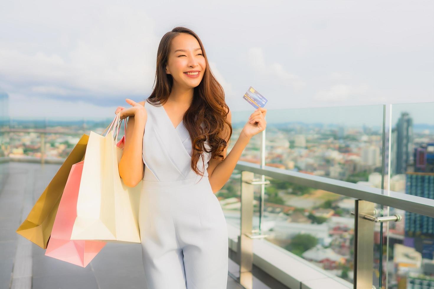 Portrait beautiful young asian woman happy and smile with credit card for shopping bag from department store photo