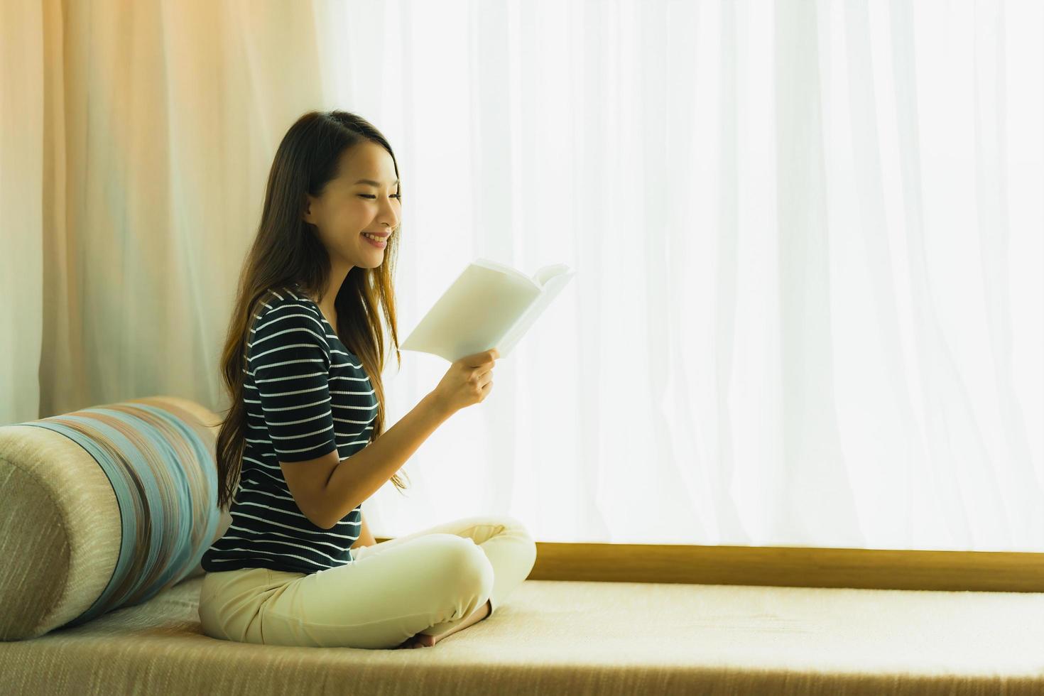 Portrait beautiful young asian woman reading book in on sofa in living room area photo