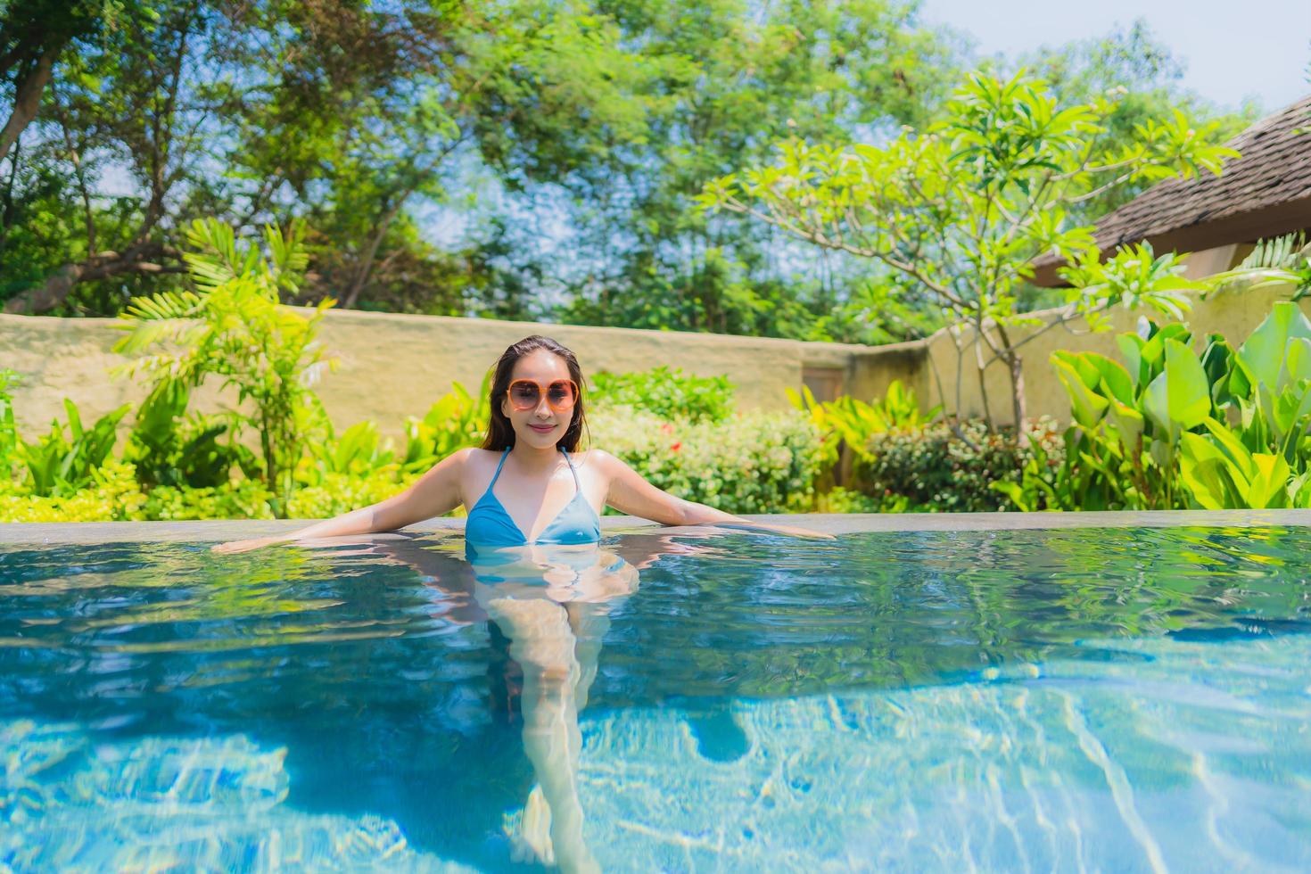 Portrait beautiful young asian woman smile happy relax and leisure in the swimming pool photo