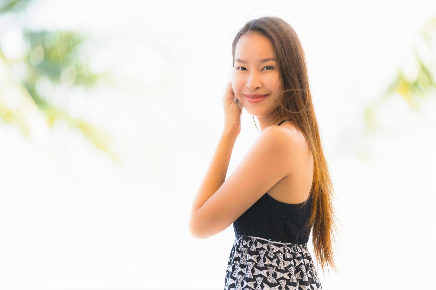 Portrait beautiful young asian woman happy and smile with travel in hotel resort neary sea and beach photo