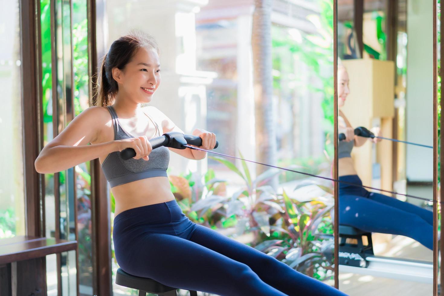 Portrait beautiful young asian woman exercise with fitness equipment in gym interior photo