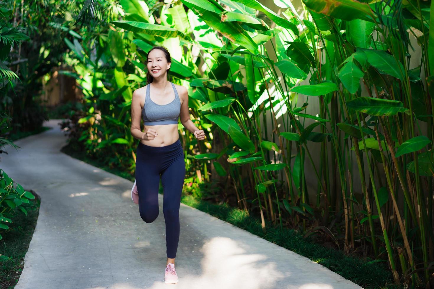 retrato, hermoso, joven, mujer asiática, funcionamiento, con, feliz, y, sonrisa, en el jardín foto