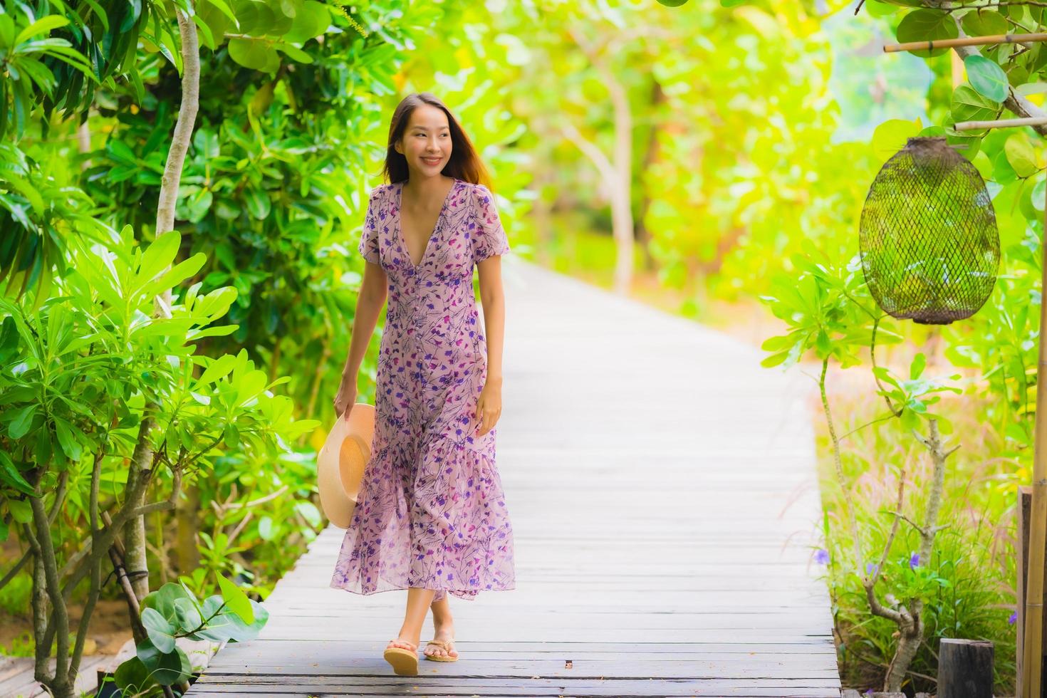 Portrait beautiful young asian woman walk on path walk in the garden photo