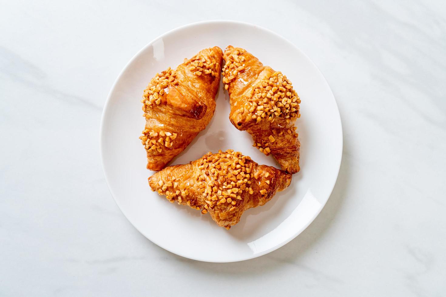 Fresh croissant with peanut on plate photo