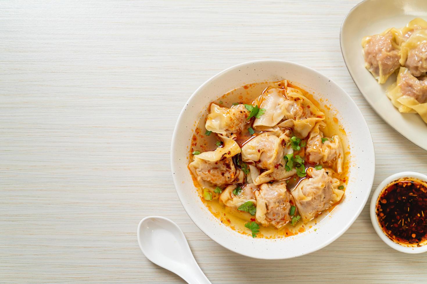 Pork wonton soup or pork dumplings soup with roasted chili - Asian food style photo