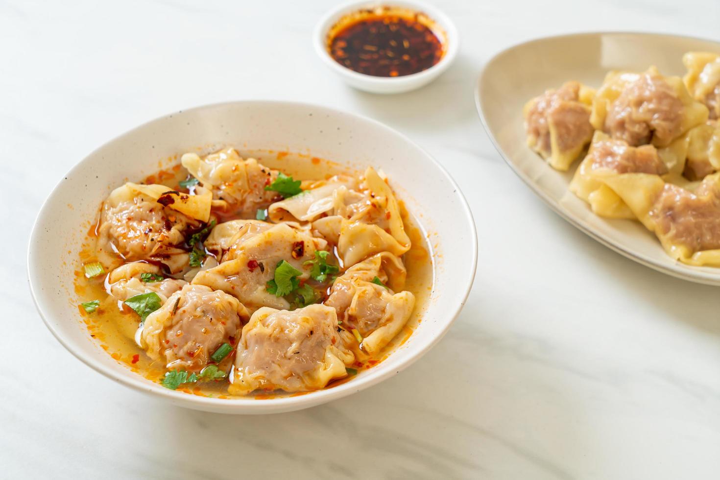 Pork wonton soup or pork dumplings soup with roasted chili - Asian food style photo