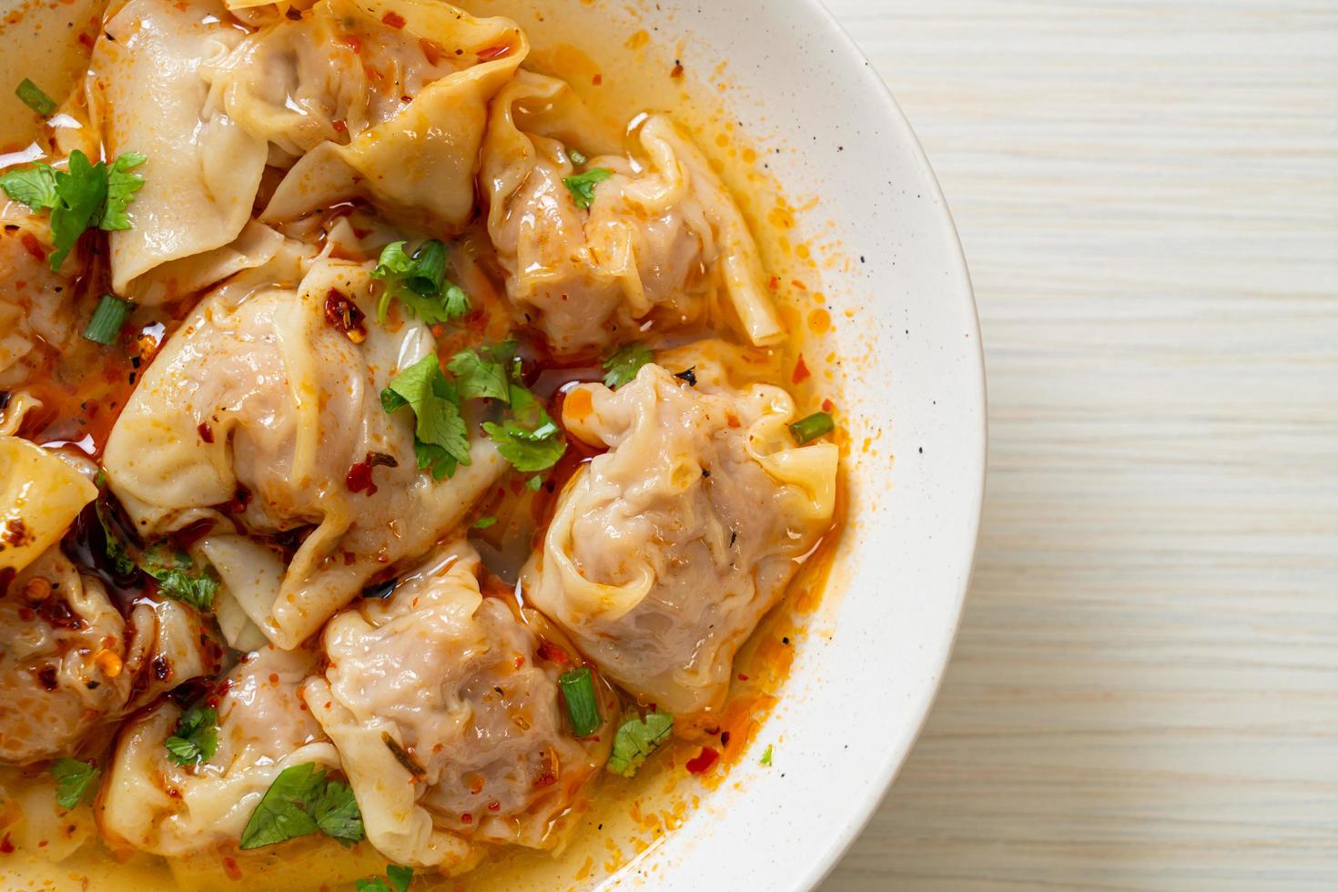 Pork wonton soup or pork dumplings soup with roasted chili - Asian food style photo