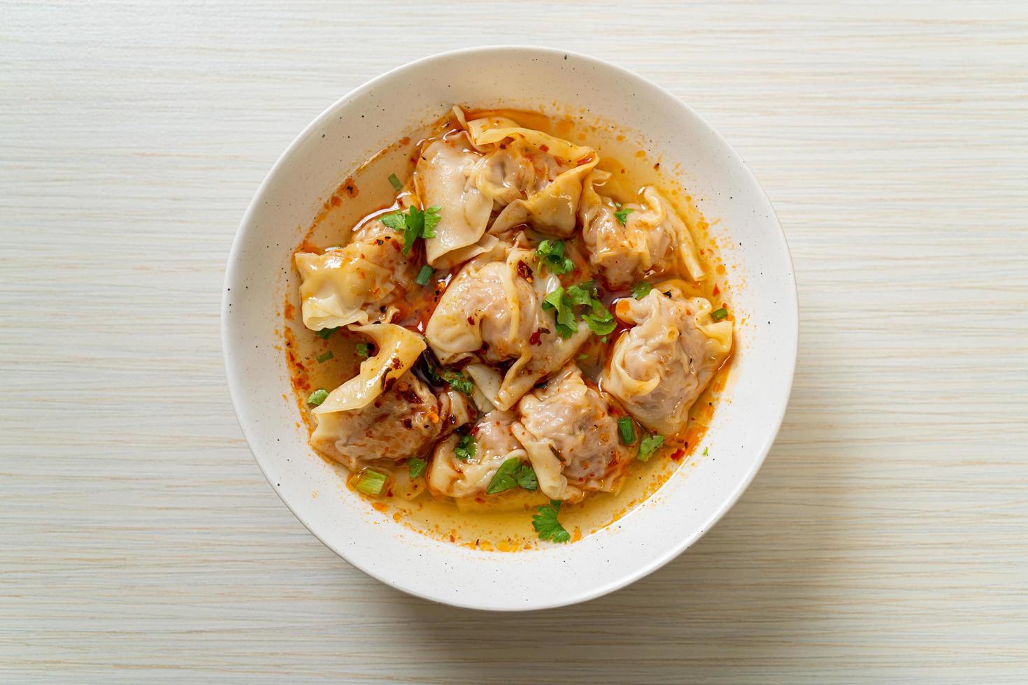 Pork wonton soup or pork dumplings soup with roasted chili - Asian food style photo