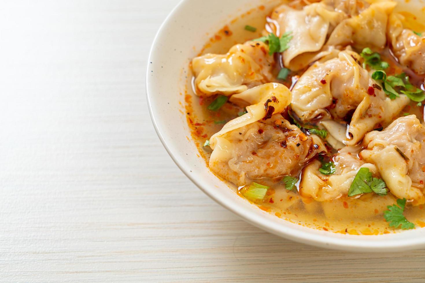 sopa de wonton de cerdo o sopa de albóndigas de cerdo con chile asado - estilo de comida asiática foto