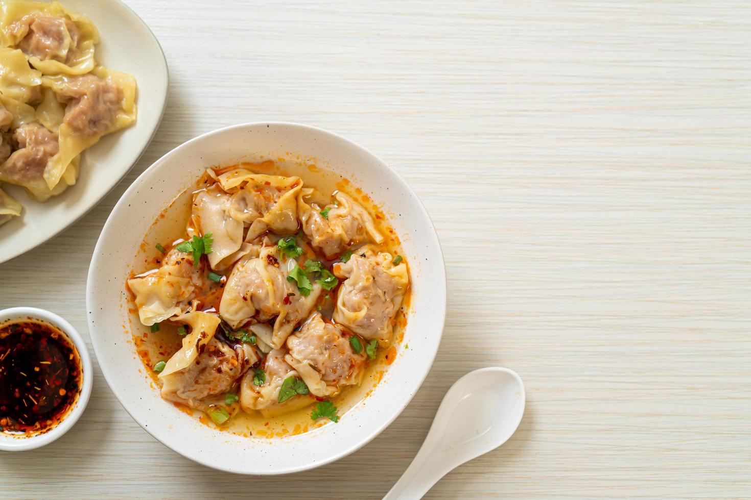 Pork wonton soup or pork dumplings soup with roasted chili - Asian food style photo