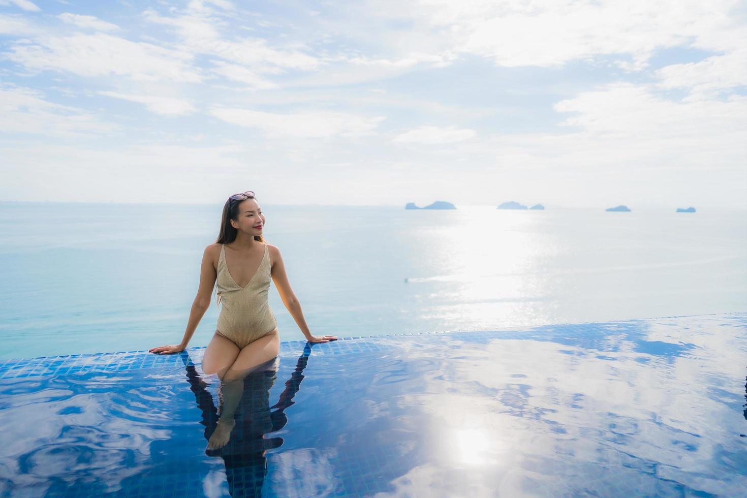 Portrait young asian woman relax smile happy around swimming pool in hotel and resort photo