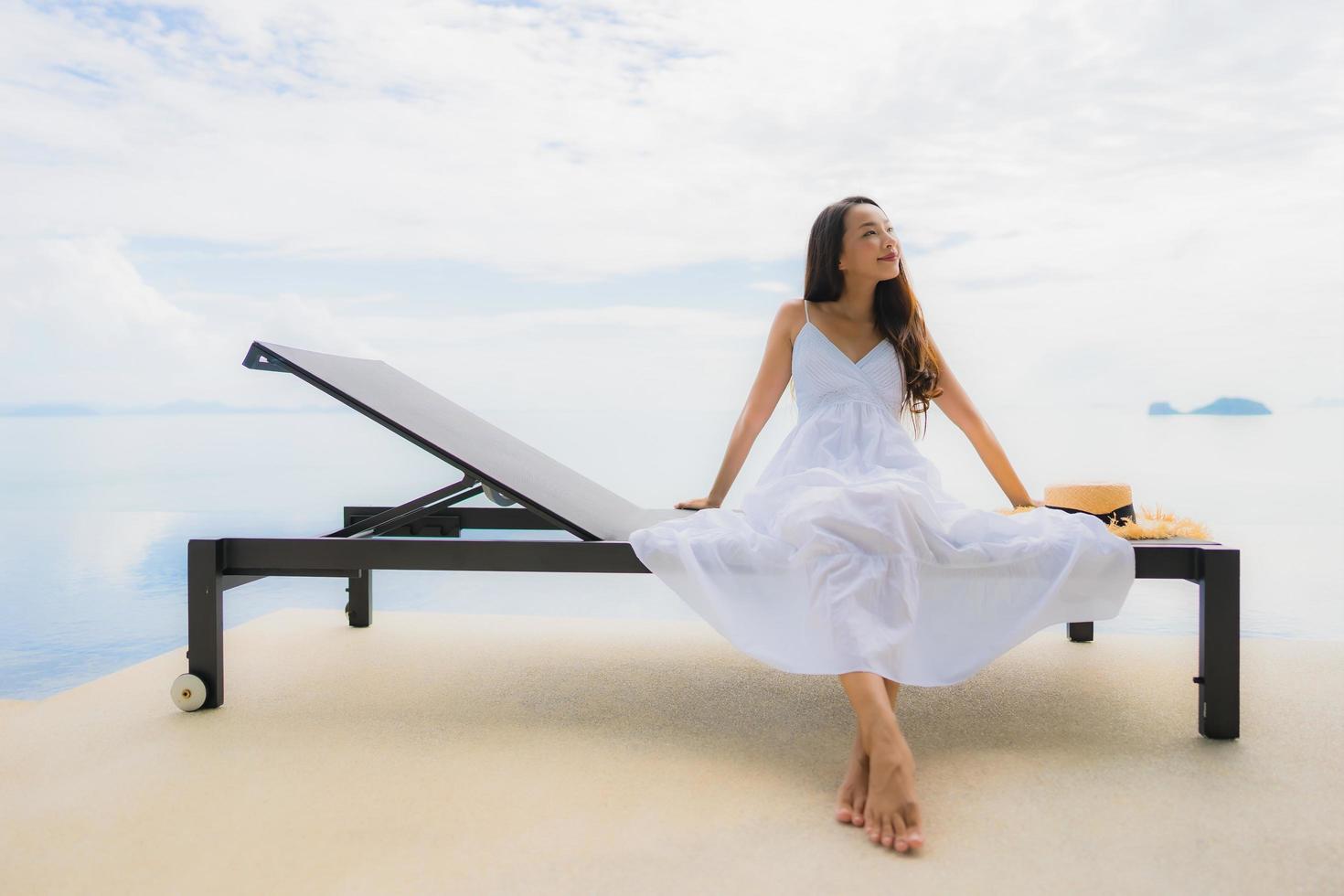 Portrait young asian woman relax smile happy around swimming pool in hotel and resort photo