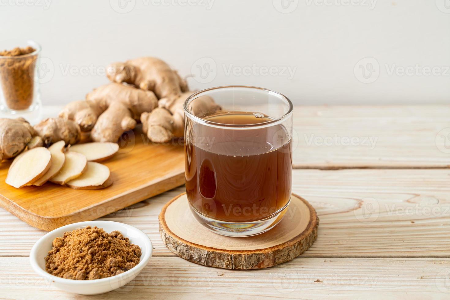 Hot and sweet ginger juice glass with ginger roots - Healthy drink style photo